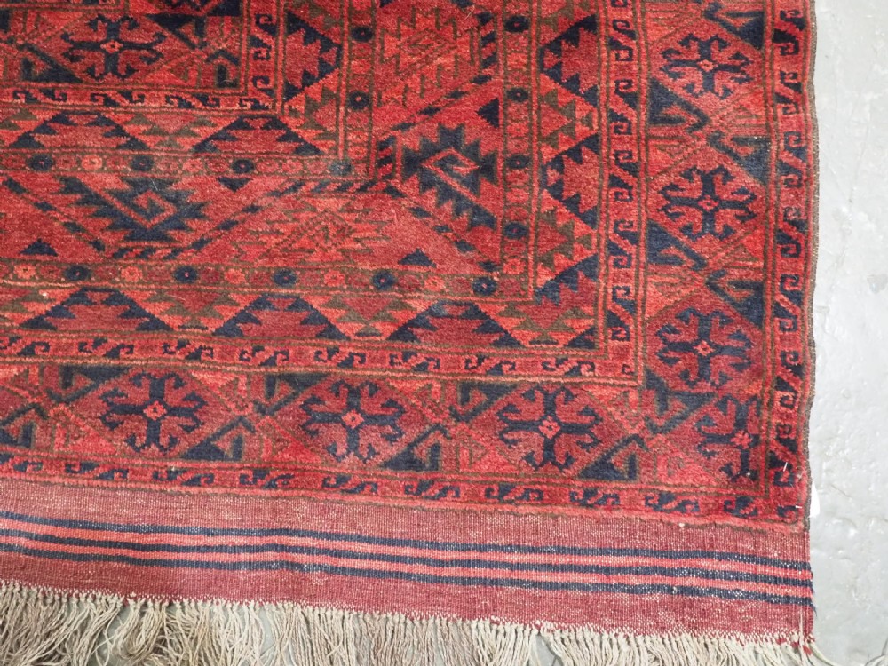 A large antique Afghan Ersari hand-knotted wool carpet featuring repeating octagonal gul motifs across a deep red field framed by geometric borders. View XII