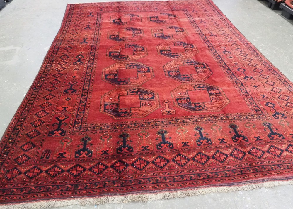 An antique hand-knotted Afghan Ersari wool carpet featuring repeating octagonal gul motifs across a deep red field framed by geometric borders. View II
