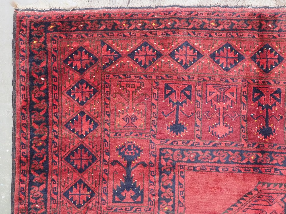 An antique hand-knotted Afghan Ersari wool carpet featuring repeating octagonal gul motifs across a deep red field framed by geometric borders. View VI