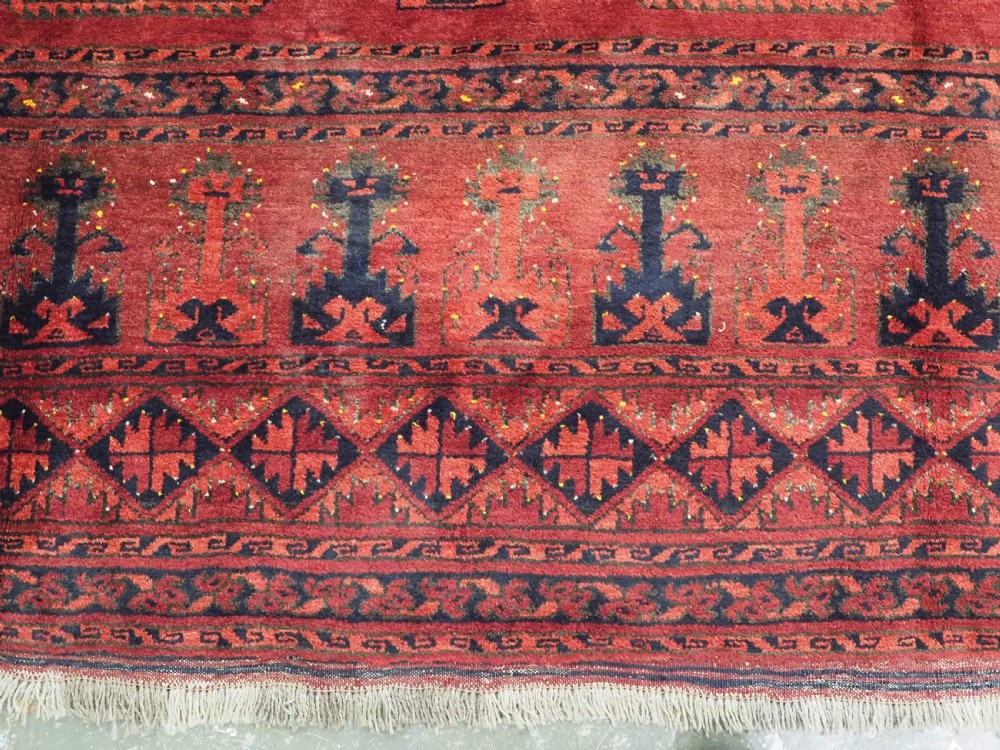 An antique hand-knotted Afghan Ersari wool carpet featuring repeating octagonal gul motifs across a deep red field framed by geometric borders. View VIII