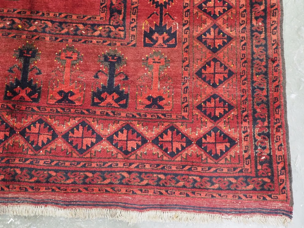 An antique hand-knotted Afghan Ersari wool carpet featuring repeating octagonal gul motifs across a deep red field framed by geometric borders. View IX