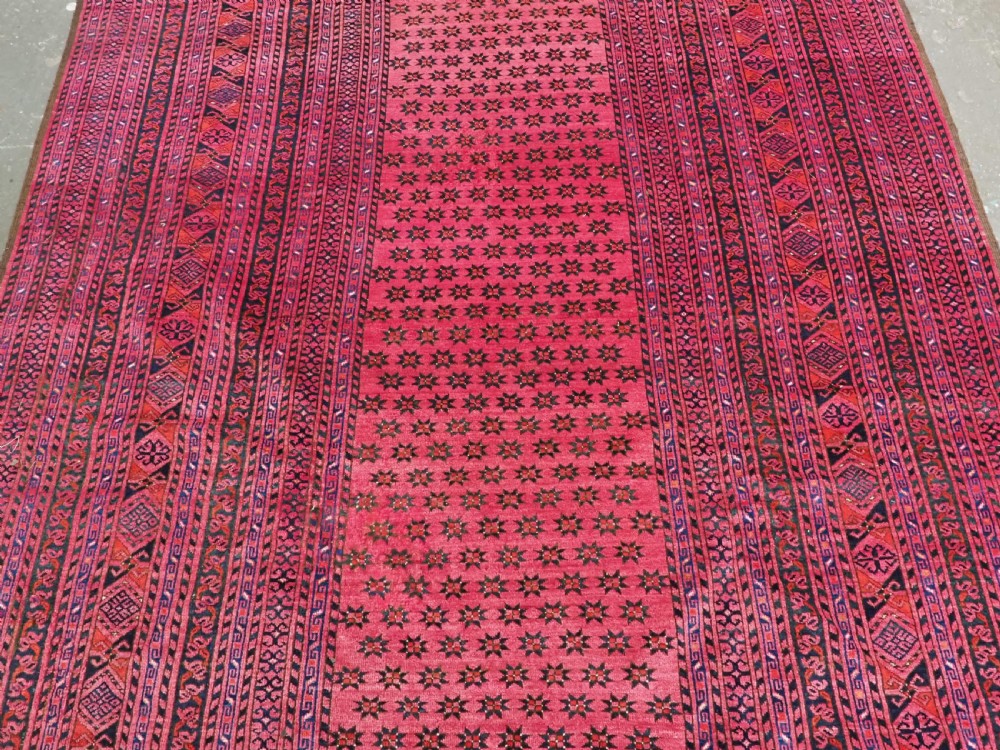 An elongated antique Afghan Ersari wool kelleh carpet featuring intricate geometric repeating motifs in shades of red, crimson, and black. View V