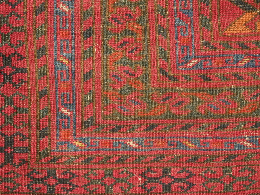 An elongated antique Afghan Ersari wool kelleh carpet featuring intricate geometric repeating motifs in shades of red, crimson, and black. View XI