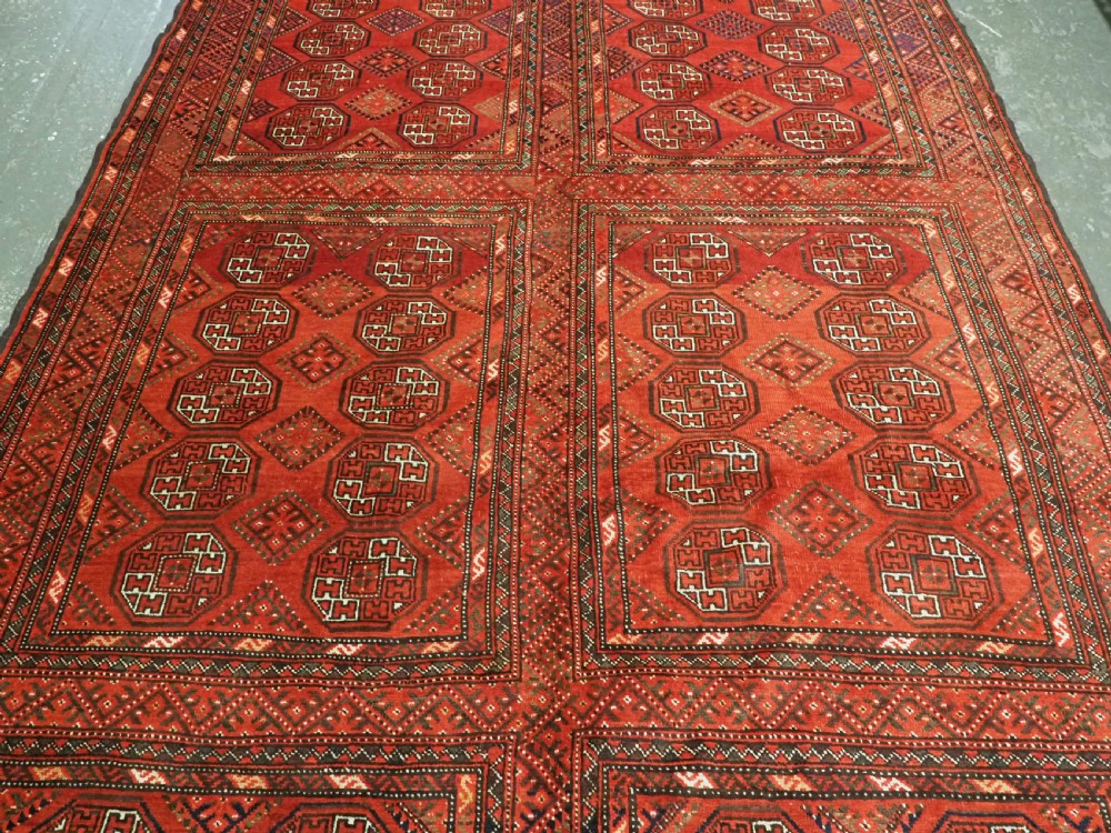 An elongated antique Turkmen Kizil Ayak wool carpet featuring multiple rectangular compartments filled with octagonal geometric guls in deep red, navy blue, and ivory tones. View VI