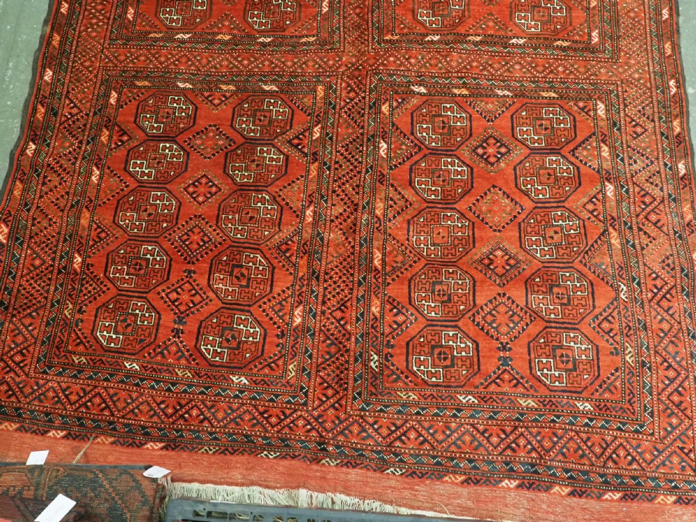 An elongated antique Turkmen Kizil Ayak wool carpet featuring multiple rectangular compartments filled with octagonal geometric guls in deep red, navy blue, and ivory tones. View VII