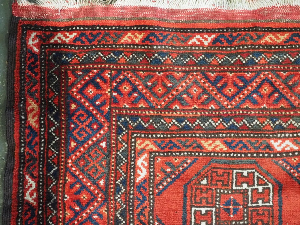 An elongated antique Turkmen Kizil Ayak wool carpet featuring multiple rectangular compartments filled with octagonal geometric guls in deep red, navy blue, and ivory tones. View VIII