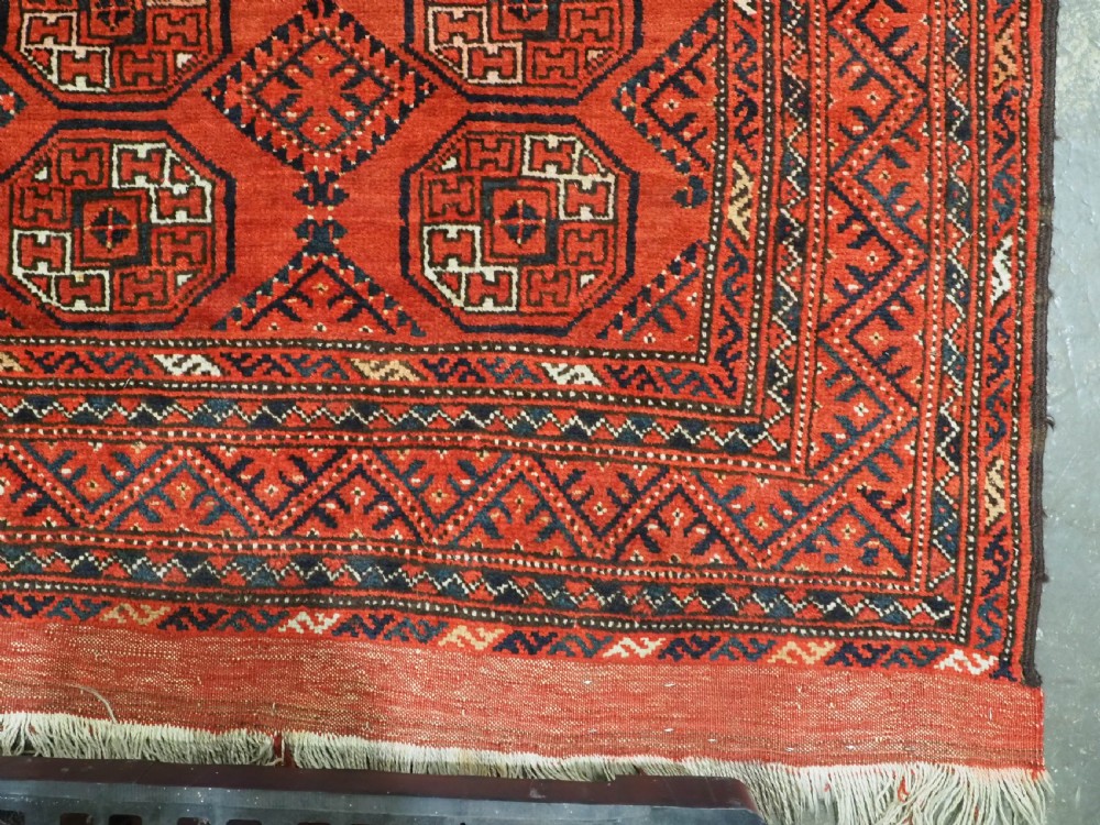 An elongated antique Turkmen Kizil Ayak wool carpet featuring multiple rectangular compartments filled with octagonal geometric guls in deep red, navy blue, and ivory tones. View XIV