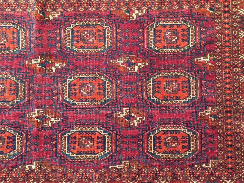 An antique woven crimson wool Tekke Turkmen chuval face featuring twelve octagonal turreted guls arranged in a rectangular grid. View VII