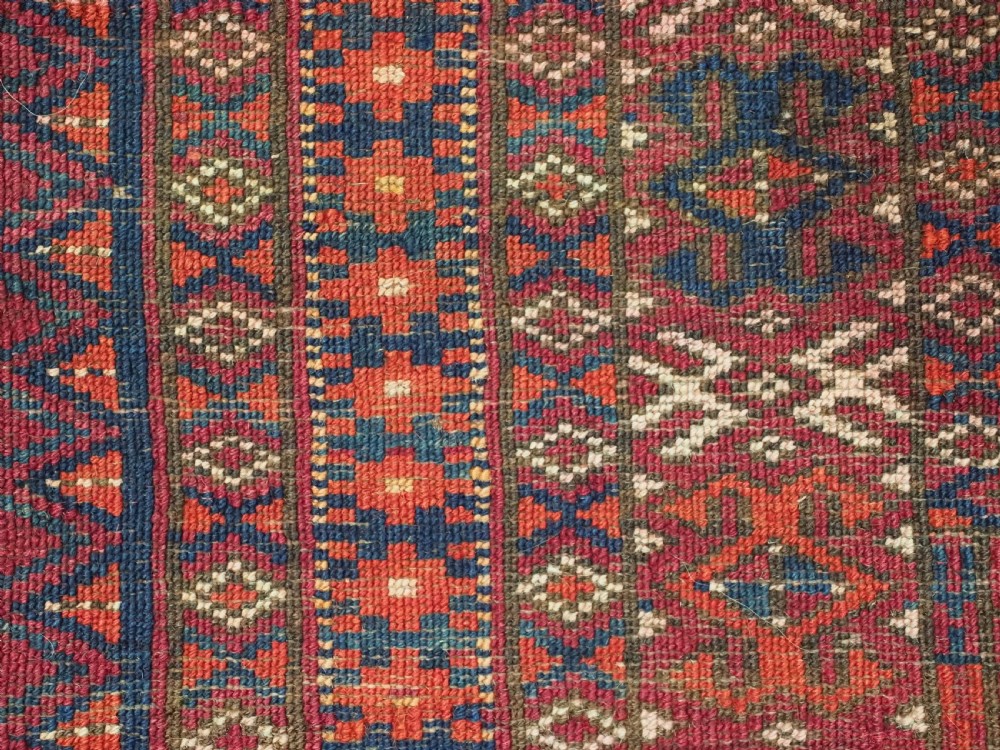 An antique woven crimson wool Tekke Turkmen chuval face featuring twelve octagonal turreted guls arranged in a rectangular grid. View XII