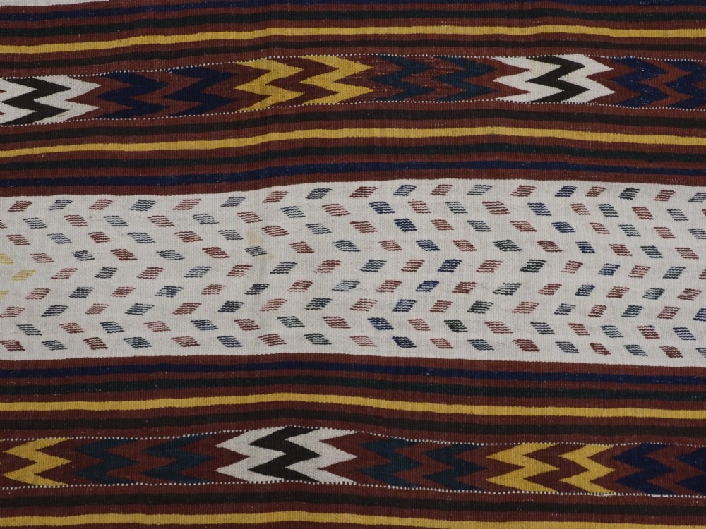 A long handwoven flatweave Central Asian kilim runner displaying cream sections alternating with dark brown, yellow, and red geometric bands with fringe at both ends. View XI