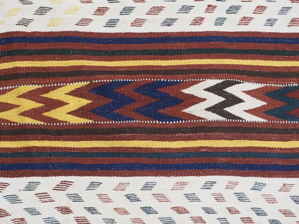 A long handwoven flatweave Central Asian kilim runner displaying cream sections alternating with dark brown, yellow, and red geometric bands with fringe at both ends. View XII