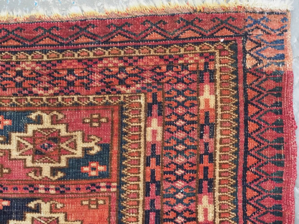 A small rectangular antique Tekke Turkmen mafrash wool panel featuring a repeating grid of geometric aina gul motifs in deep red, dark blue, and cream. View VIII