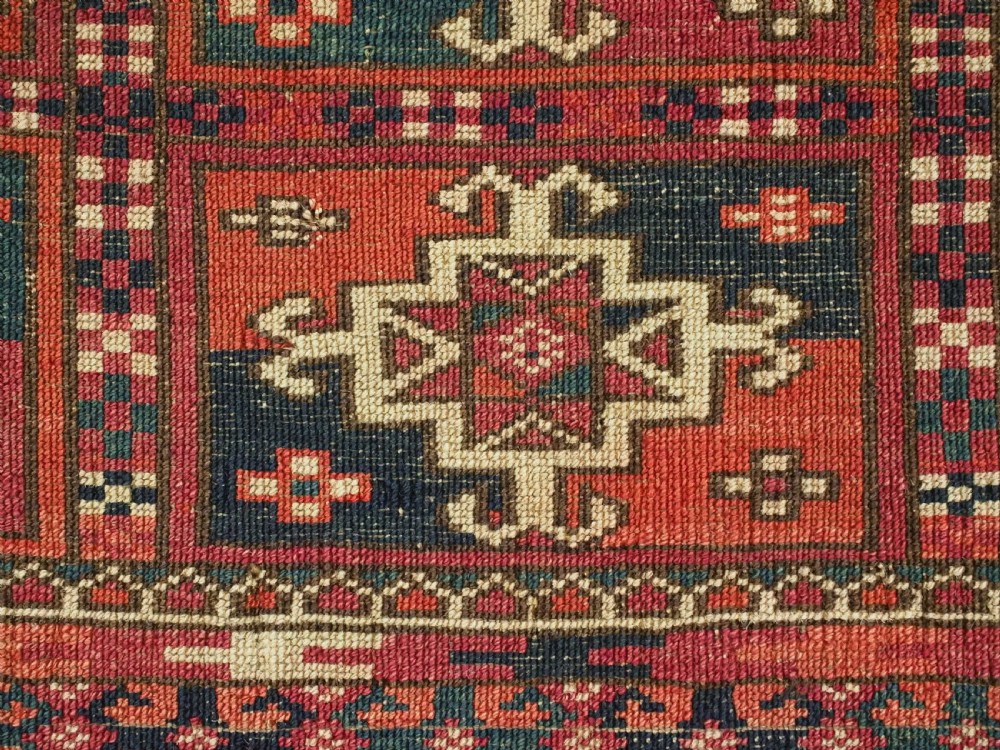 A small rectangular antique Tekke Turkmen mafrash wool panel featuring a repeating grid of geometric aina gul motifs in deep red, dark blue, and cream. View XI