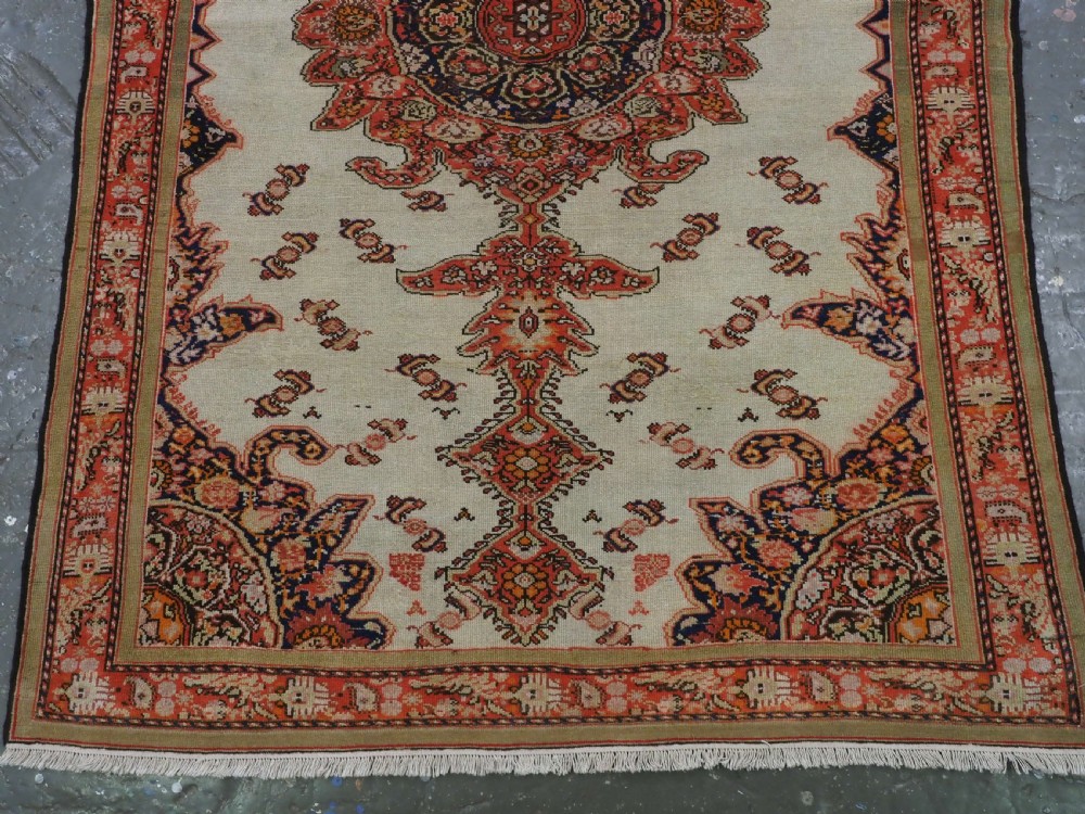 An antique Persian Malayer hand-knotted wool rug featuring an ivory central field, a complex terracotta and navy medallion, butterfly motifs, and a detailed multi-stripe border. View V
