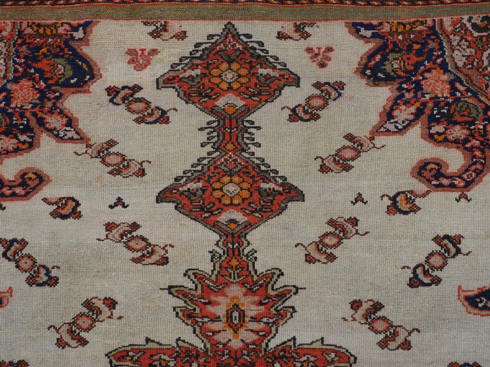 An antique Persian Malayer hand-knotted wool rug featuring an ivory central field, a complex terracotta and navy medallion, butterfly motifs, and a detailed multi-stripe border. View IX