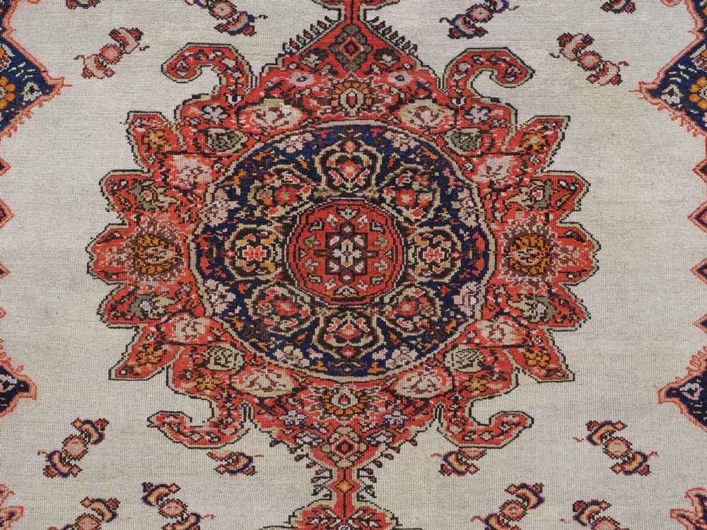 An antique Persian Malayer hand-knotted wool rug featuring an ivory central field, a complex terracotta and navy medallion, butterfly motifs, and a detailed multi-stripe border. View X
