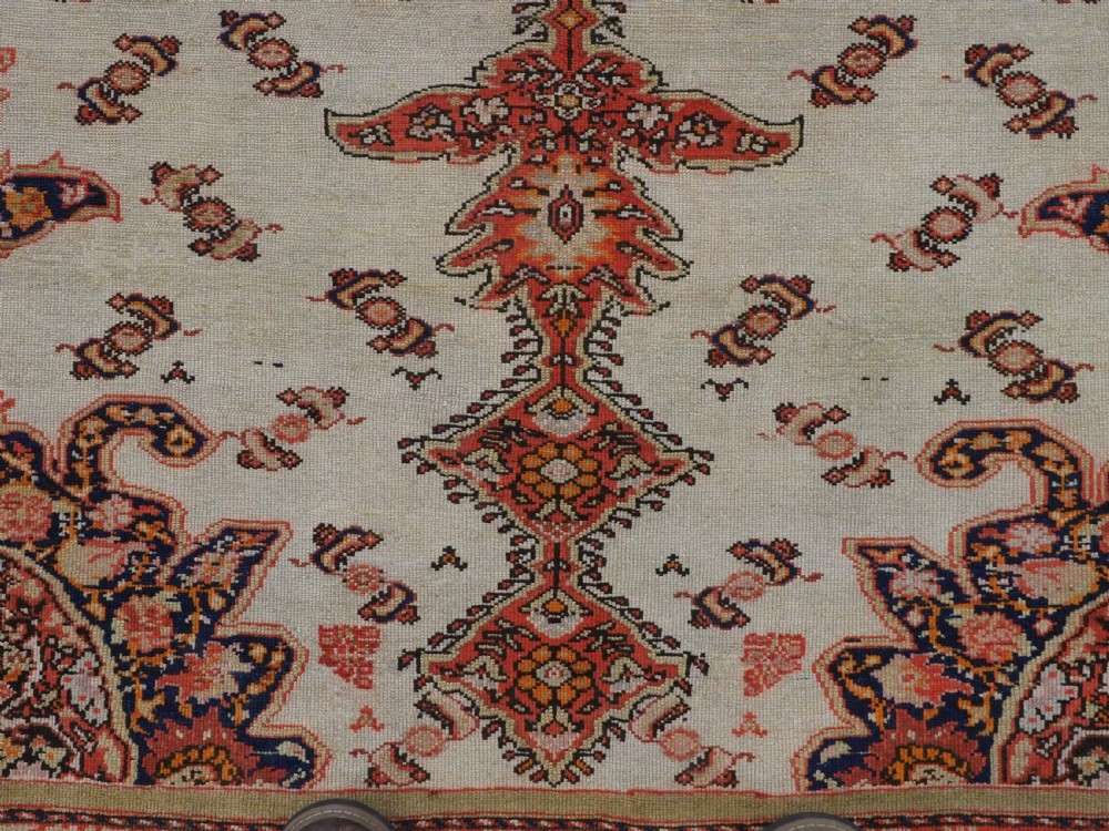 An antique Persian Malayer hand-knotted wool rug featuring an ivory central field, a complex terracotta and navy medallion, butterfly motifs, and a detailed multi-stripe border. View XI