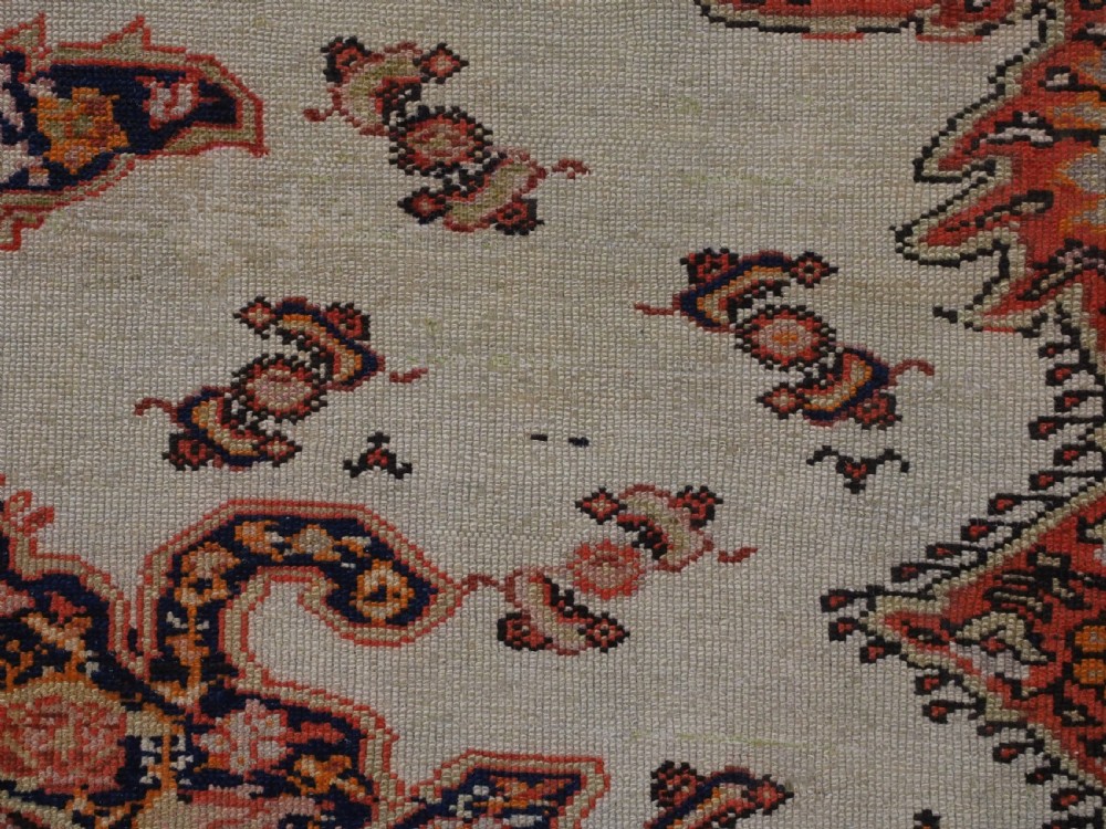 An antique Persian Malayer hand-knotted wool rug featuring an ivory central field, a complex terracotta and navy medallion, butterfly motifs, and a detailed multi-stripe border. View XII