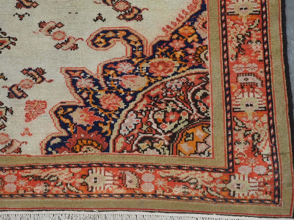 An antique Persian Malayer hand-knotted wool rug featuring an ivory central field, a complex terracotta and navy medallion, butterfly motifs, and a detailed multi-stripe border. View XIII