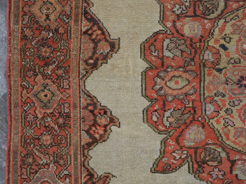 An antique hand-knotted Persian Malayer rug featuring a central terracotta medallion on a cream field with geometric patterned borders. View VII