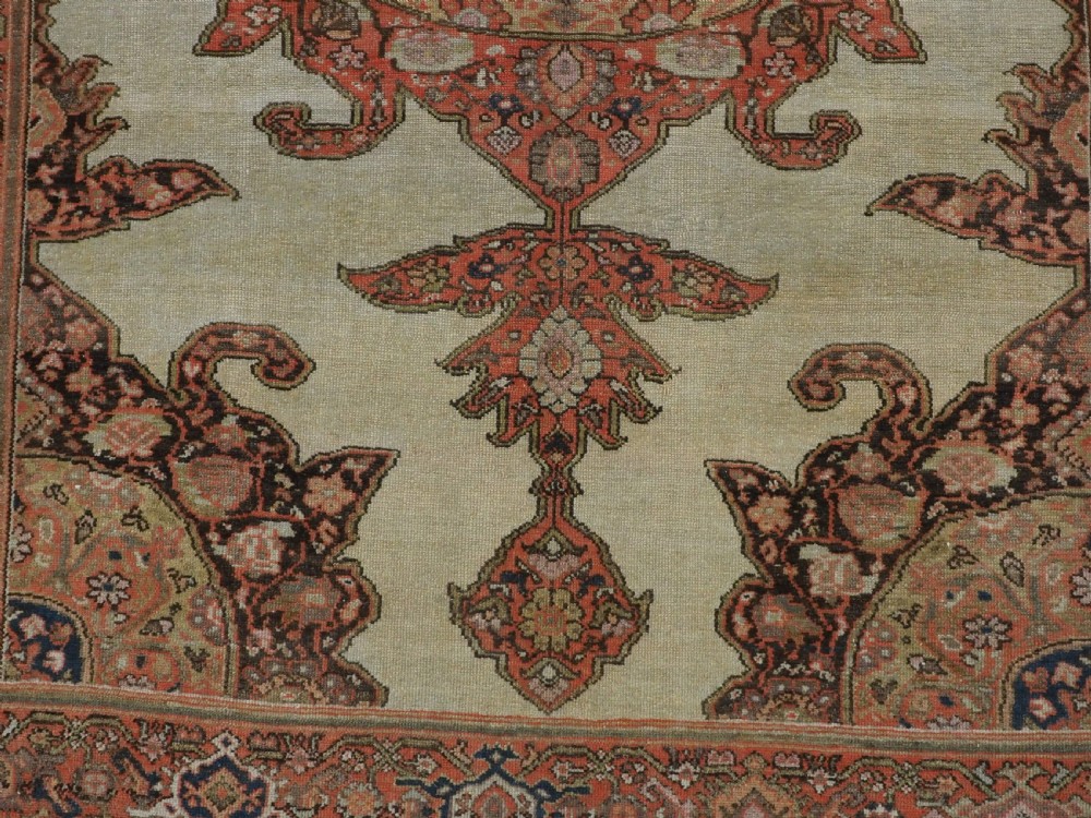 An antique hand-knotted Persian Malayer rug featuring a central terracotta medallion on a cream field with geometric patterned borders. View X