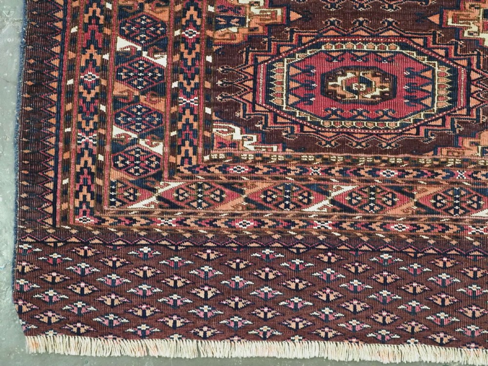 An antique Saryk Turkmen chuval face featuring nine octagonal Salor guls in deep crimson, brown, and white with geometric borders. View V