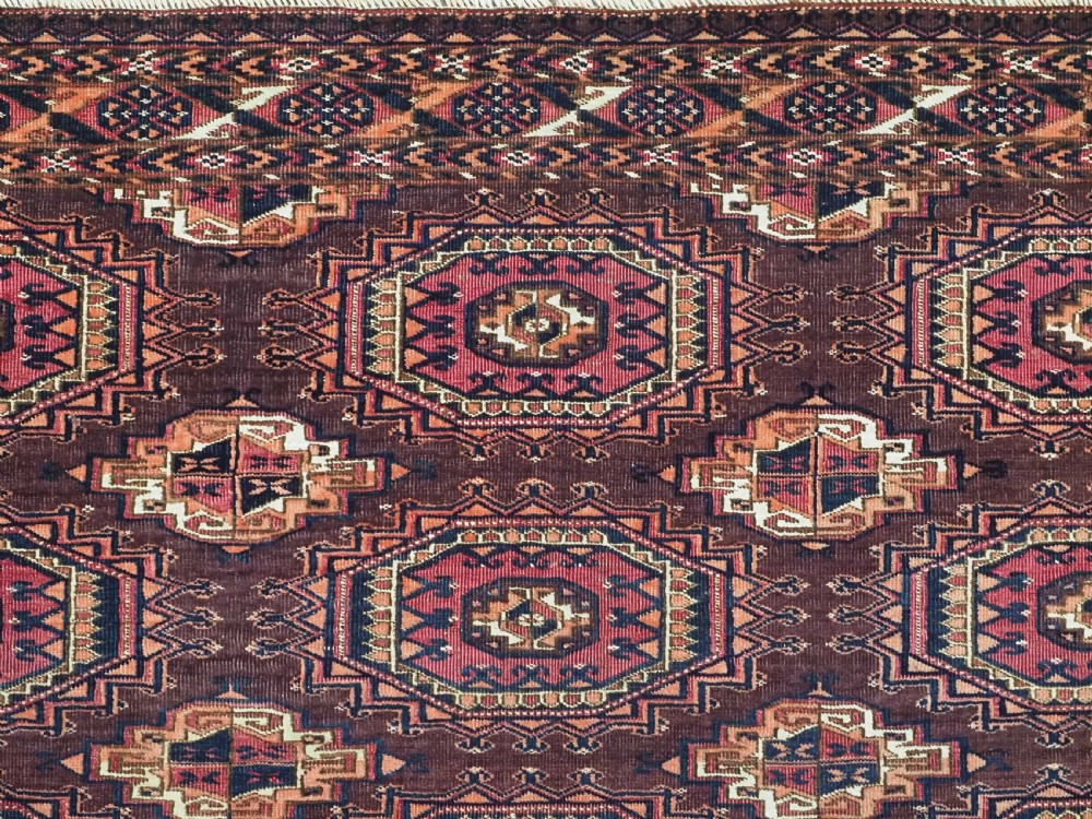 An antique Saryk Turkmen chuval face featuring nine octagonal Salor guls in deep crimson, brown, and white with geometric borders. View VI