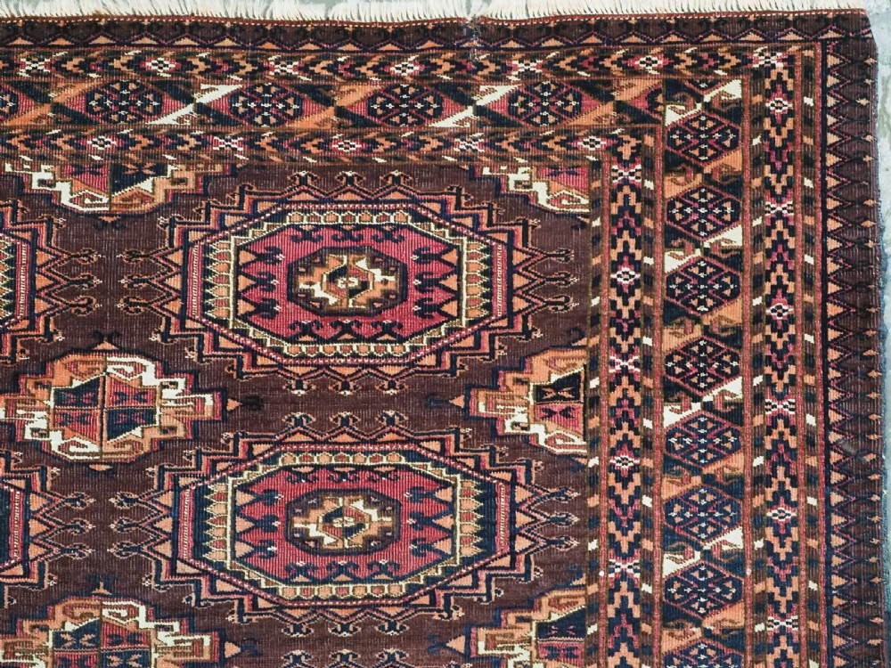 An antique Saryk Turkmen chuval face featuring nine octagonal Salor guls in deep crimson, brown, and white with geometric borders. View VIII