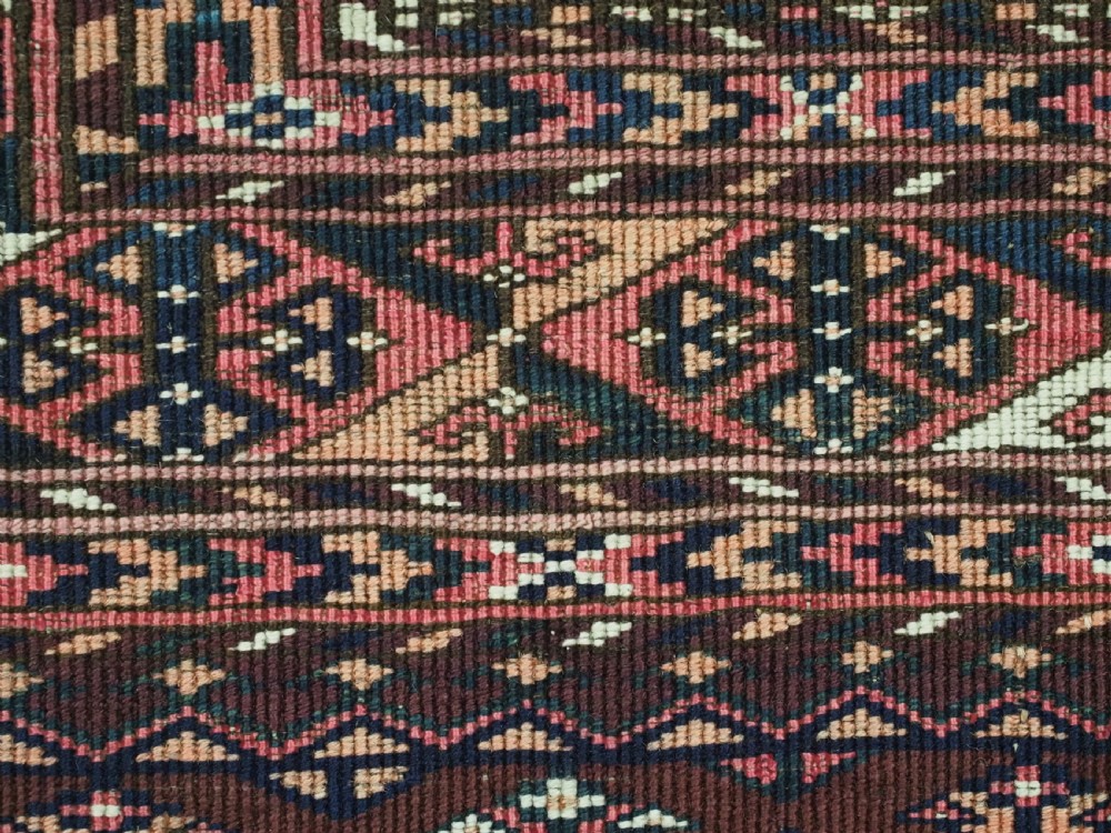 An antique Saryk Turkmen chuval face featuring nine octagonal Salor guls in deep crimson, brown, and white with geometric borders. View XIII