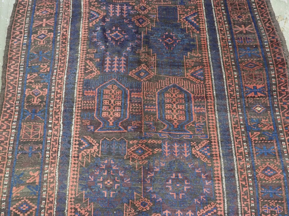 A rectangular antique hand-knotted wool carpet featuring deep indigo blue and madder red geometric motifs with geometric borders and white star details. View IV