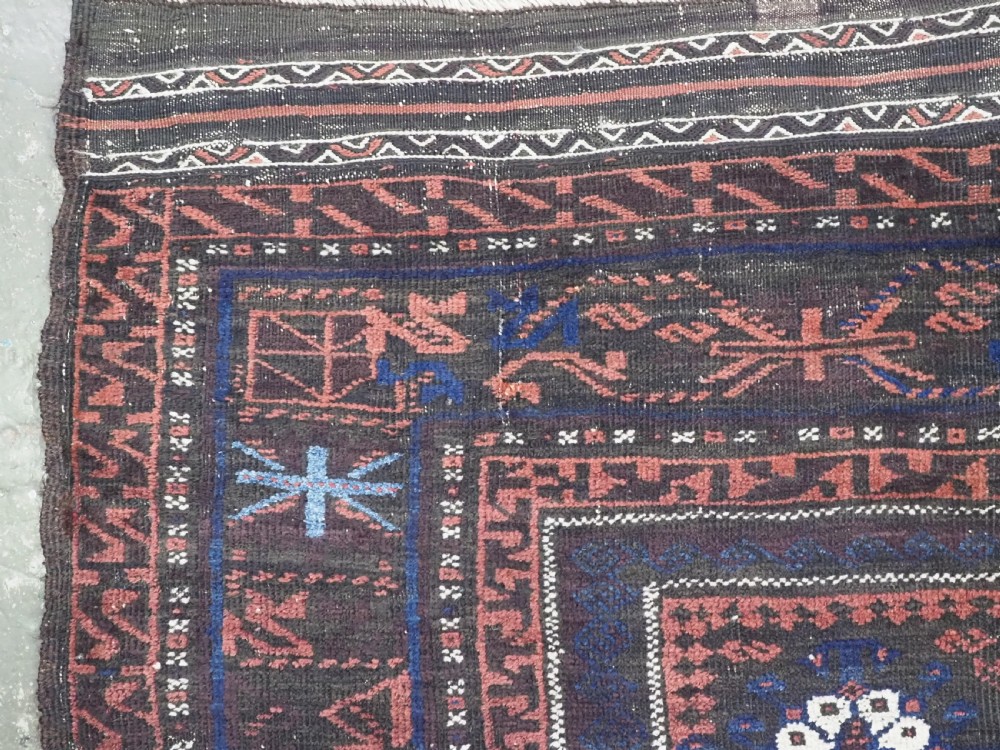 A rectangular antique hand-knotted wool carpet featuring deep indigo blue and madder red geometric motifs with geometric borders and white star details. View VII