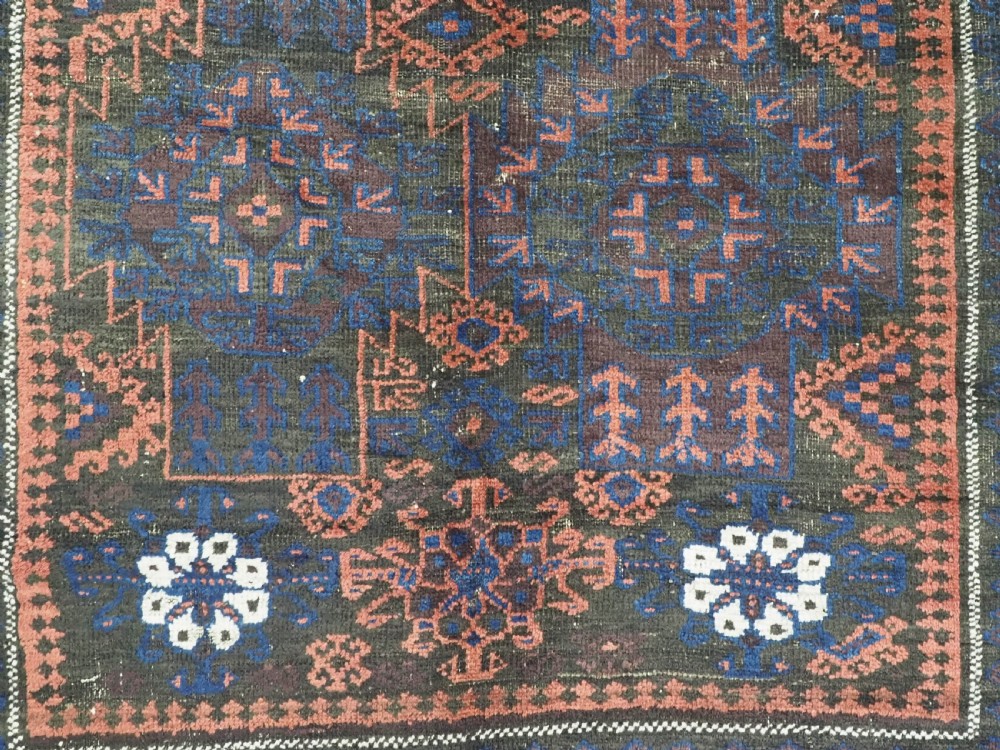A rectangular antique hand-knotted wool carpet featuring deep indigo blue and madder red geometric motifs with geometric borders and white star details. View XI