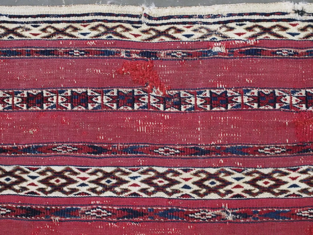 An antique Tekke Turkmen Ak chuval face displaying red and dark blue horizontal bands above a patterned ivory geometric lower panel. View VII
