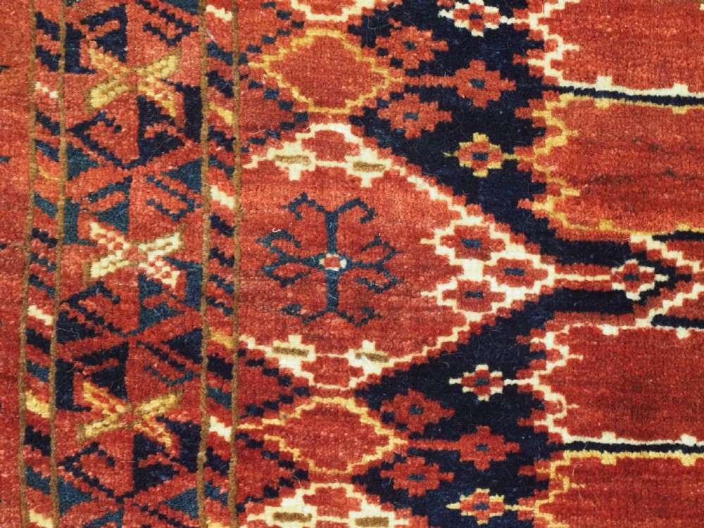 A horizontal antique hand-knotted Turkmen wool torba featuring rust red, black, and cream geometric ikat motifs. View VI