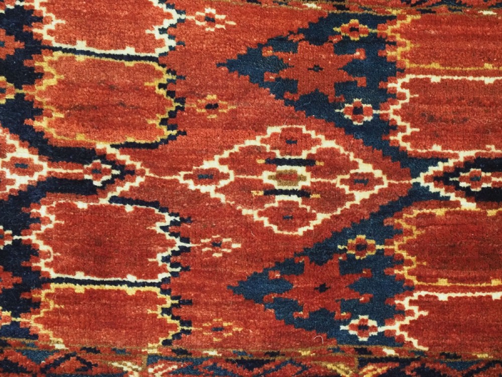A horizontal antique hand-knotted Turkmen wool torba featuring rust red, black, and cream geometric ikat motifs. View VII