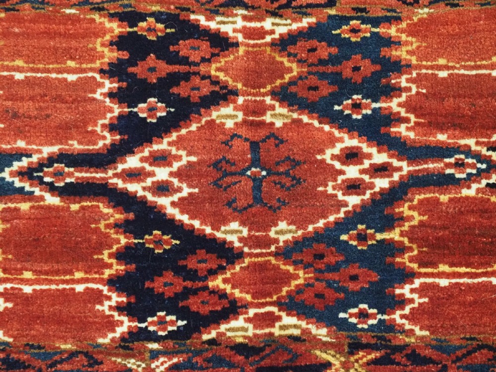 A horizontal antique hand-knotted Turkmen wool torba featuring rust red, black, and cream geometric ikat motifs. View VIII