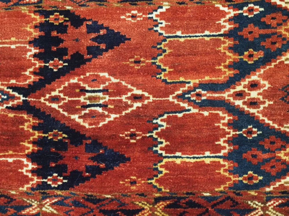 A horizontal antique hand-knotted Turkmen wool torba featuring rust red, black, and cream geometric ikat motifs. View IX