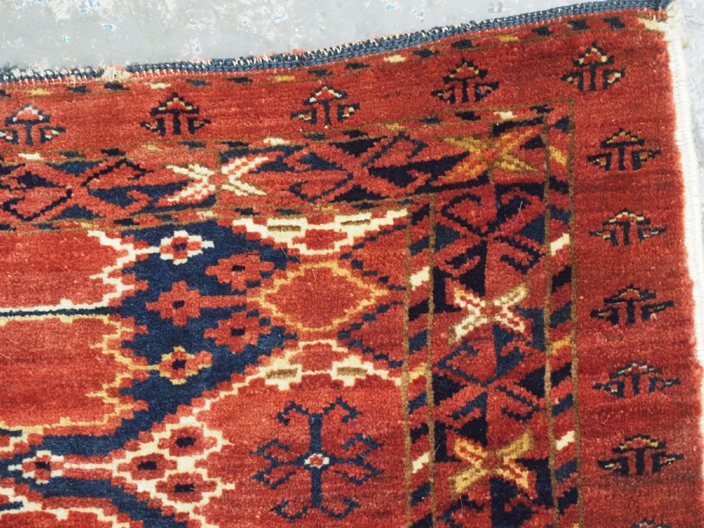 A horizontal antique hand-knotted Turkmen wool torba featuring rust red, black, and cream geometric ikat motifs. View XI