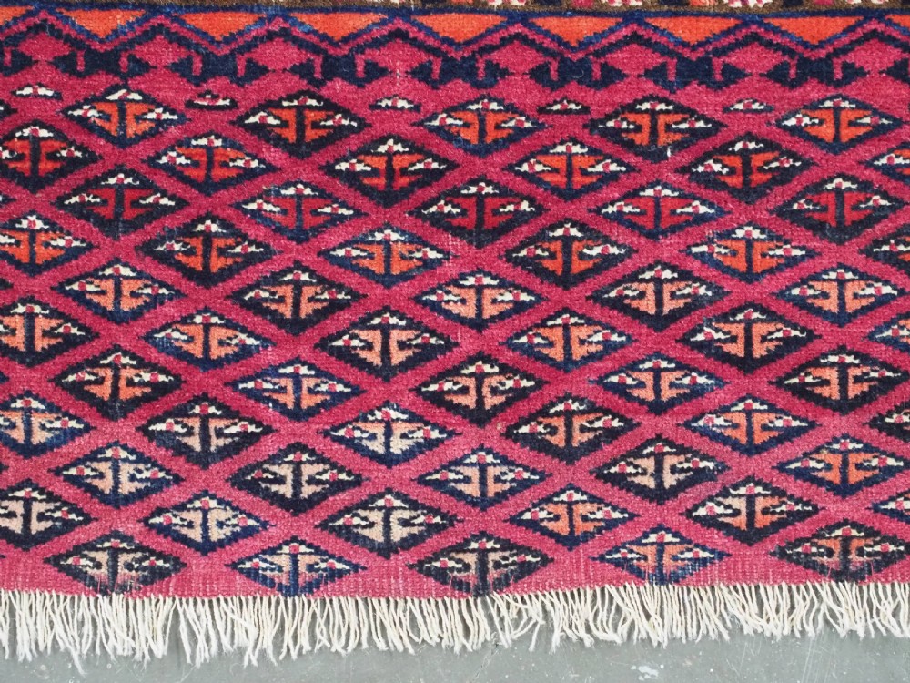 An antique woven wool Turkmen chuval face featuring nine primary octagonal gul motifs on a deep red field framed by geometric borders. View XI