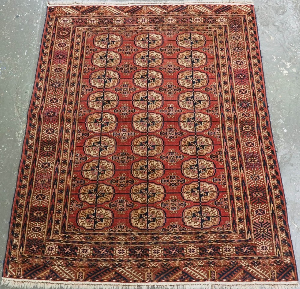ANTIQUE TEKKE TURKMEN RUG WITH SOFT MADDER RED GROUND, CIRCA 1900.