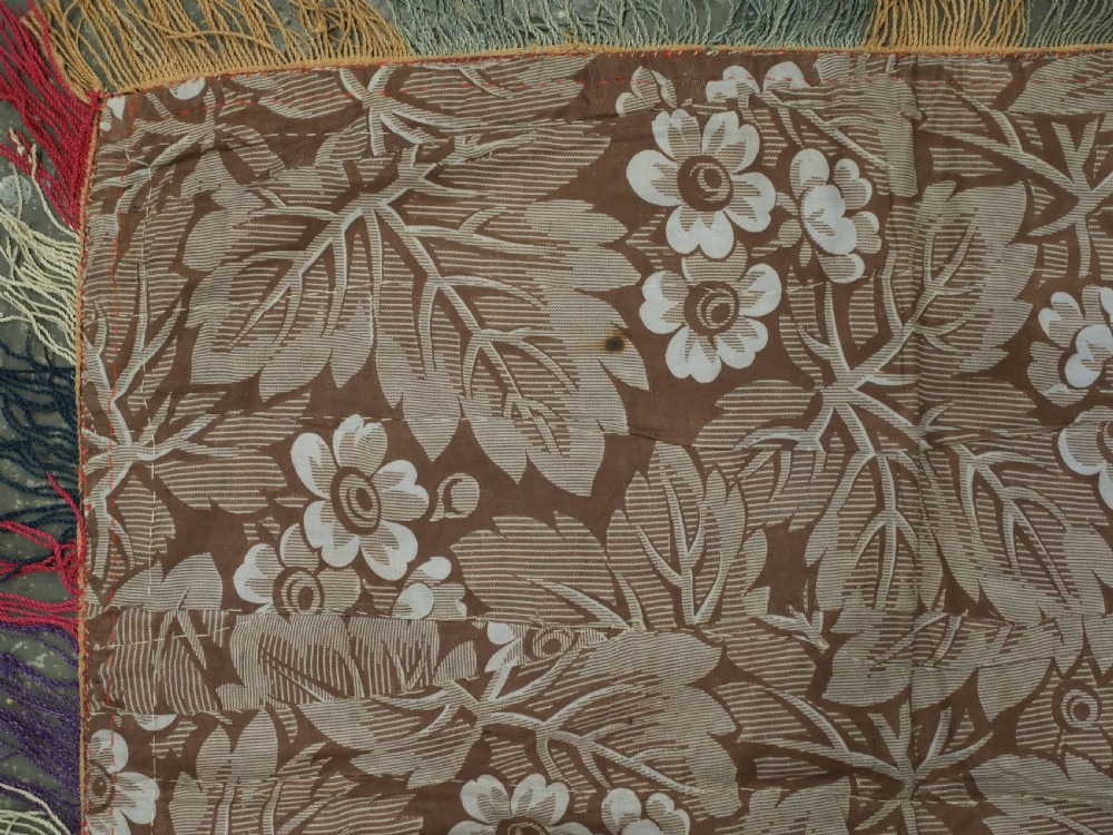 A square antique Uzbek Lakai embroidered textile featuring central circular and solar motifs in purple, red, and turquoise on a yellow fabric ground, finished with a multi-coloured fringed border. View VIII