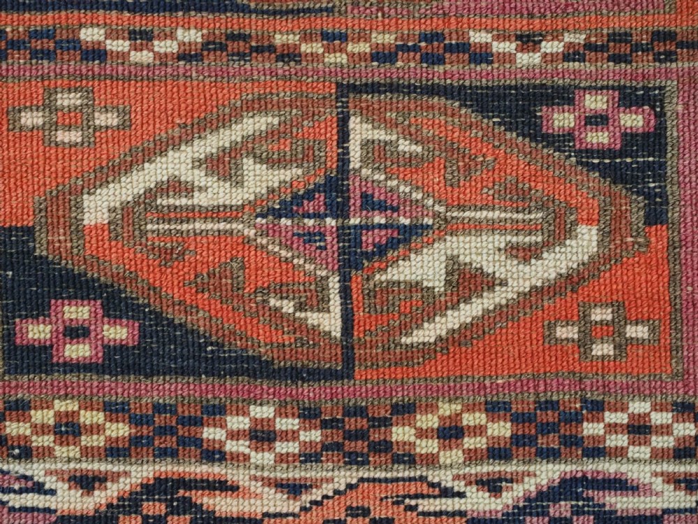 A hand-knotted wool Tekke Turkmen chuval face with repeating geometric aina gul motifs in red, navy blue, and ivory tones, finished with a fringed lower border. View XI
