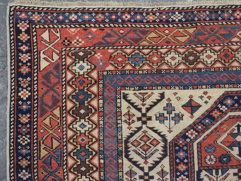An antique Caucasian Shirvan prayer rug featuring an ivory ground decorated with a geometric floral lattice pattern and a arched mihrab. View VI