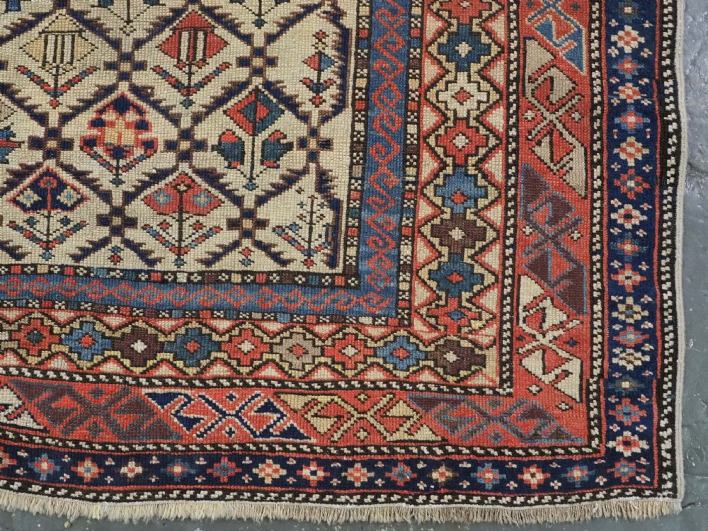An antique Caucasian Shirvan prayer rug featuring an ivory ground decorated with a geometric floral lattice pattern and a arched mihrab. View XI