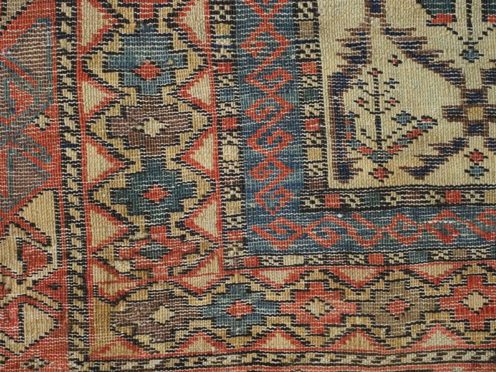An antique Caucasian Shirvan prayer rug featuring an ivory ground decorated with a geometric floral lattice pattern and a arched mihrab. View XII