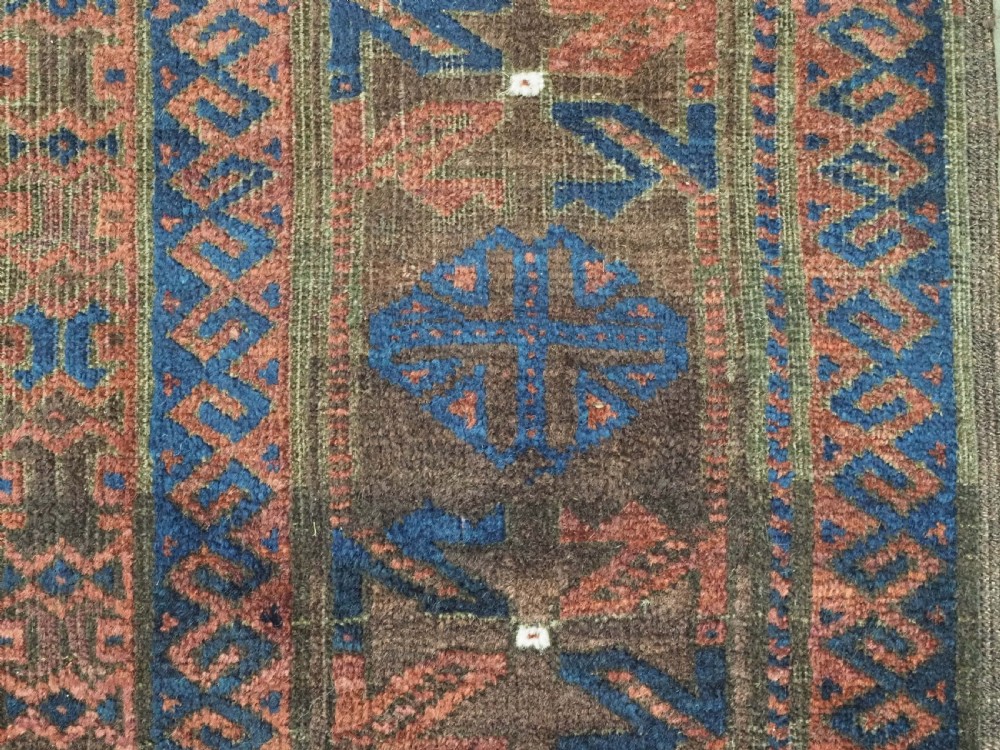 An antique hand-knotted wool carpet featuring dark brown and indigo geometric diamond medallions and detailed decorative borders. View XIV