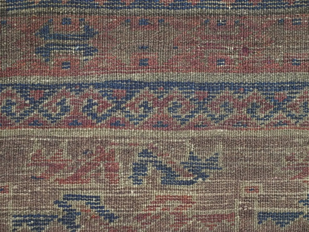 An antique hand-knotted wool carpet featuring dark brown and indigo geometric diamond medallions and detailed decorative borders. View XVI
