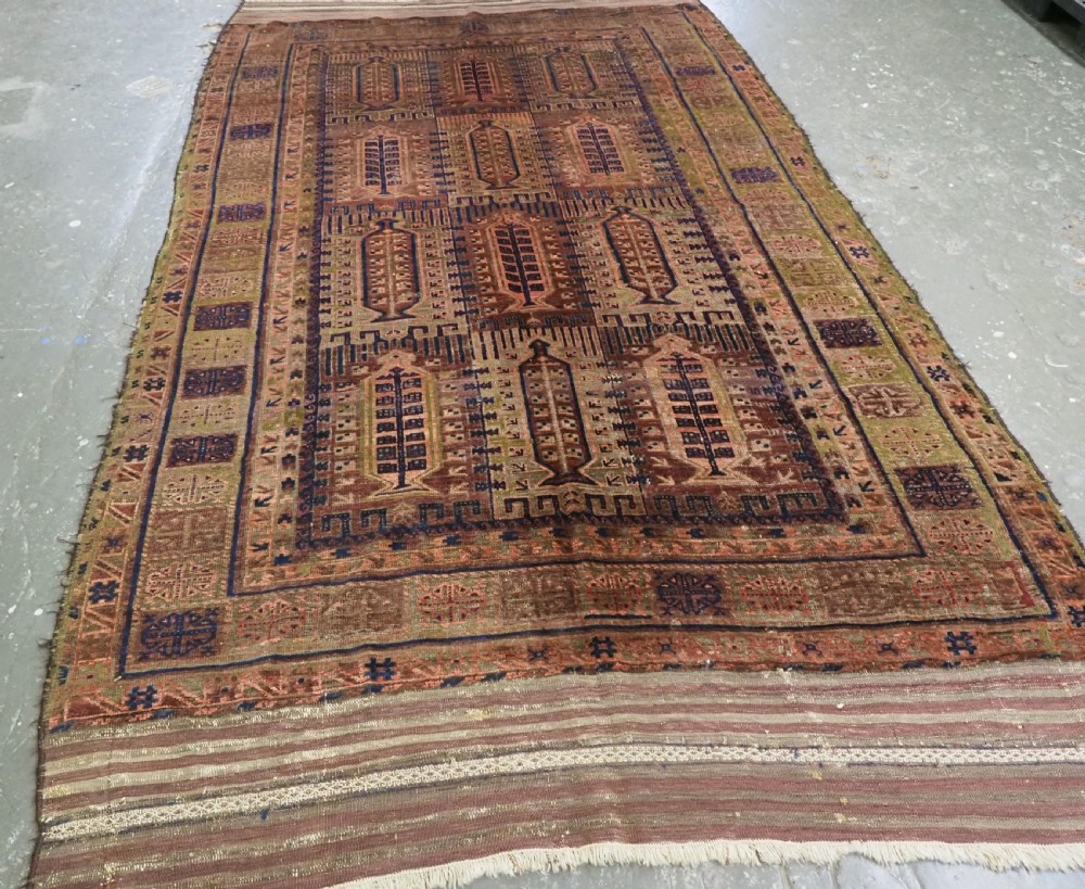 An antique hand-knotted Timuri Baluch wool carpet featuring geometric tree motifs in terracotta, indigo, and olive green hues with woven kilim borders. View II