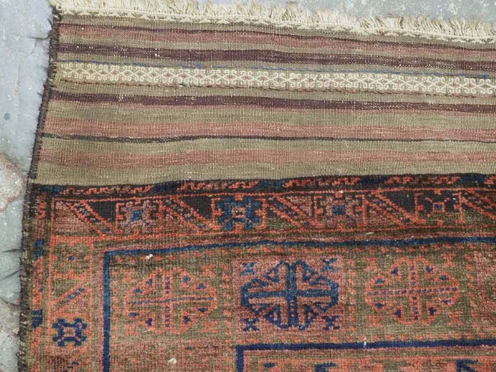An antique hand-knotted Timuri Baluch wool carpet featuring geometric tree motifs in terracotta, indigo, and olive green hues with woven kilim borders. View VI
