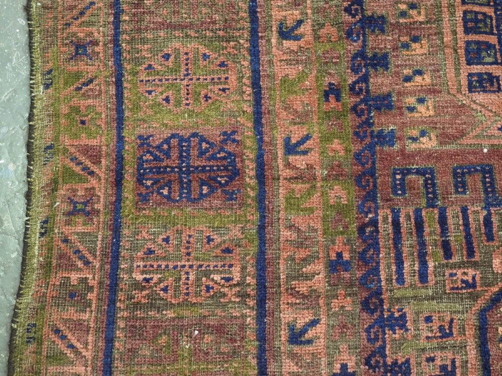 An antique hand-knotted Timuri Baluch wool carpet featuring geometric tree motifs in terracotta, indigo, and olive green hues with woven kilim borders. View VII